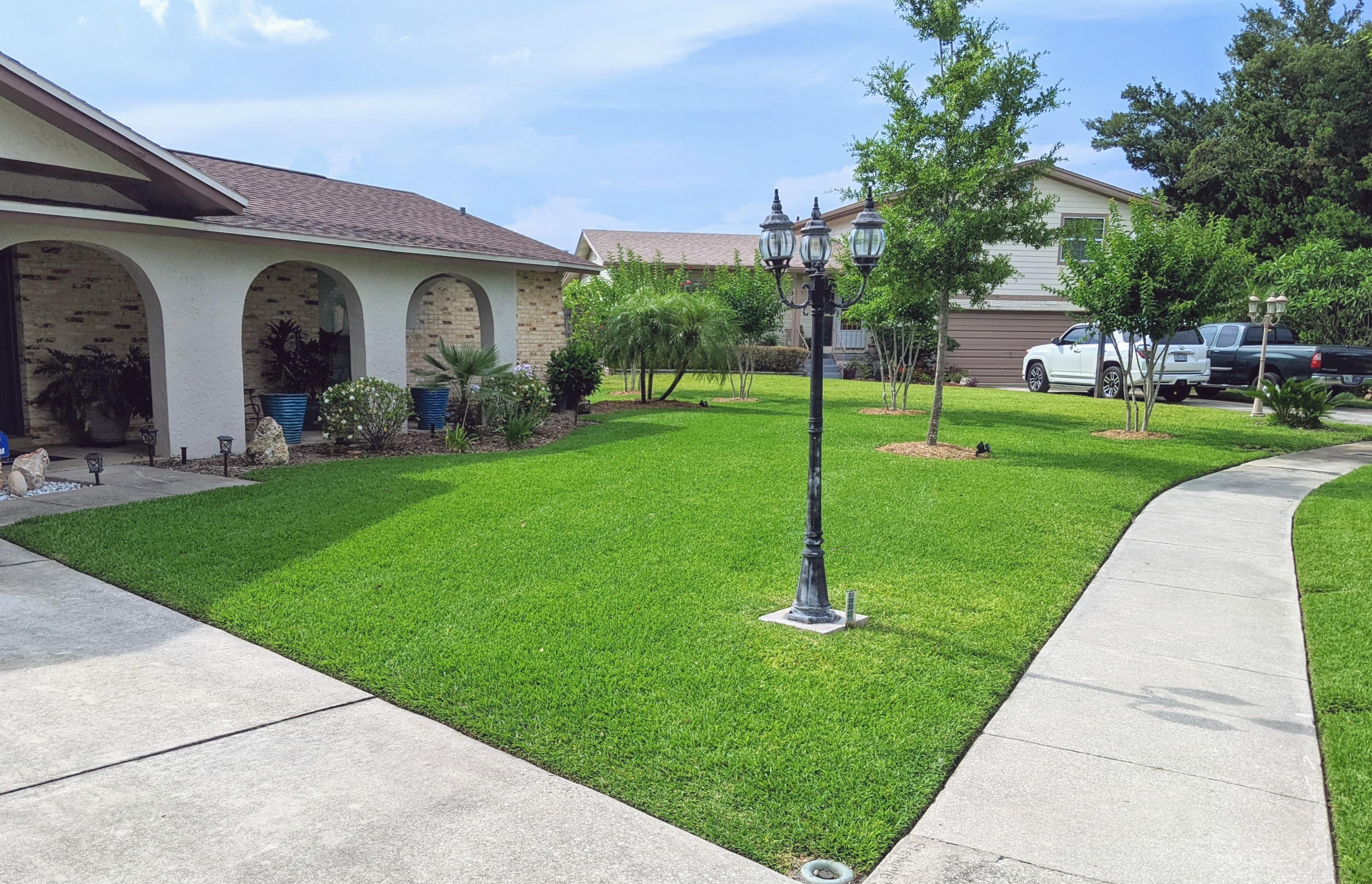 Vibrant green front yard lawn in Casselberry, FL after precision mowing and clean concrete edging by Freedom Lawn Pros